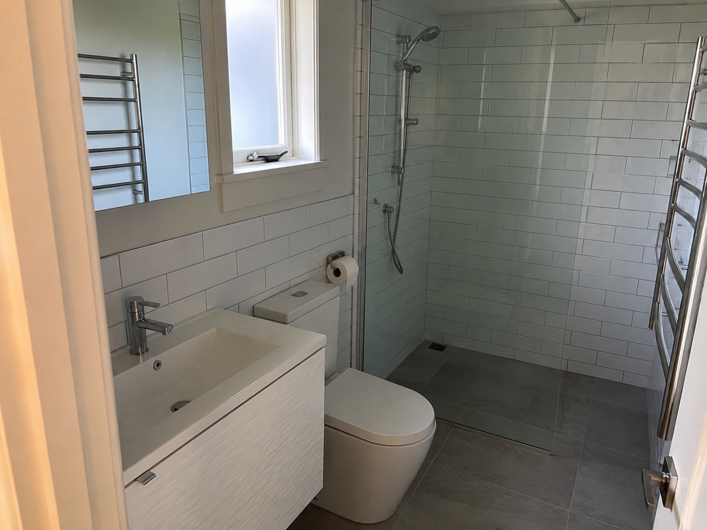 Finished bathroom renovation with walk-in tiled shower and new fixtures